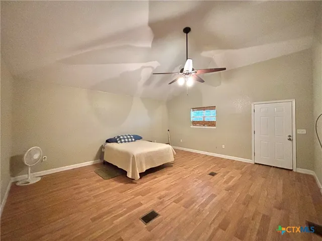 a bedroom with a bed and a wooden floor
