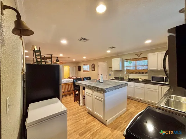a kitchen with stainless steel appliances granite countertop a refrigerator a stove and a sink