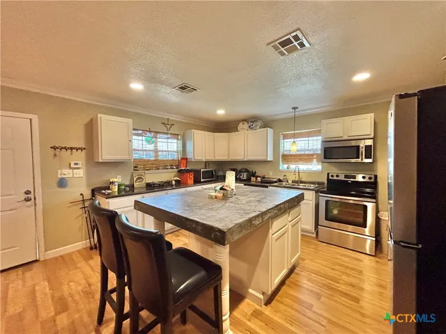 a kitchen with a stove a refrigerator and a microwave