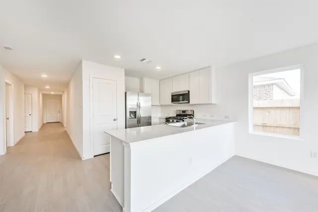 a kitchen with kitchen island sink stove and cabinets