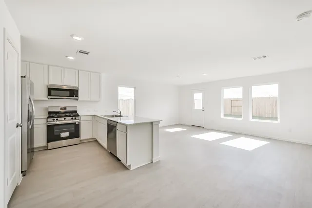 a kitchen with white cabinets stainless steel appliances and sink
