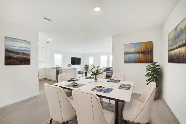 a room with a table chairs and a living room