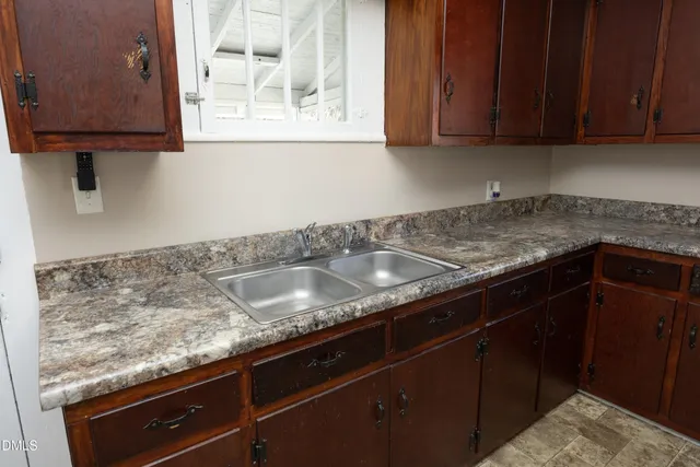 a kitchen with granite countertop a sink and a stove