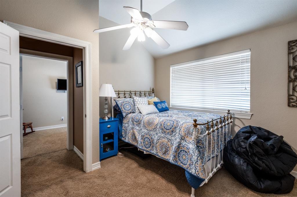 707 Bent Tree Court Coppell, TX 75019 - Photo 17 of 39 a bedroom with a bed and a chandelier