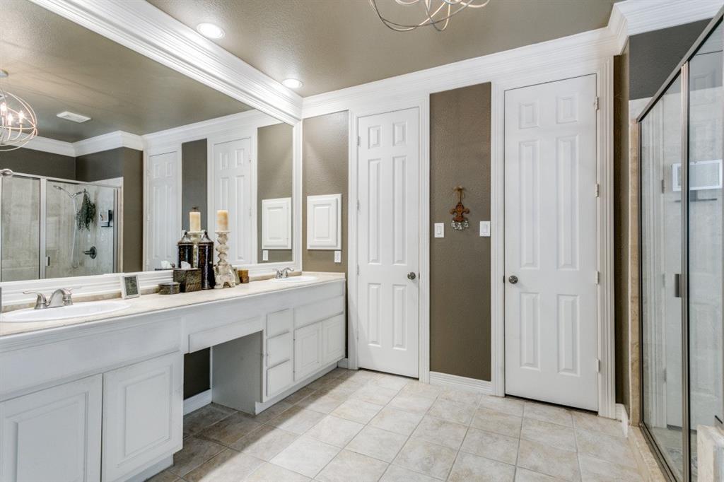 707 Bent Tree Court Coppell, TX 75019 - Photo 3 of 39 a large bathroom with a double vanity sink a large mirror and a shower
