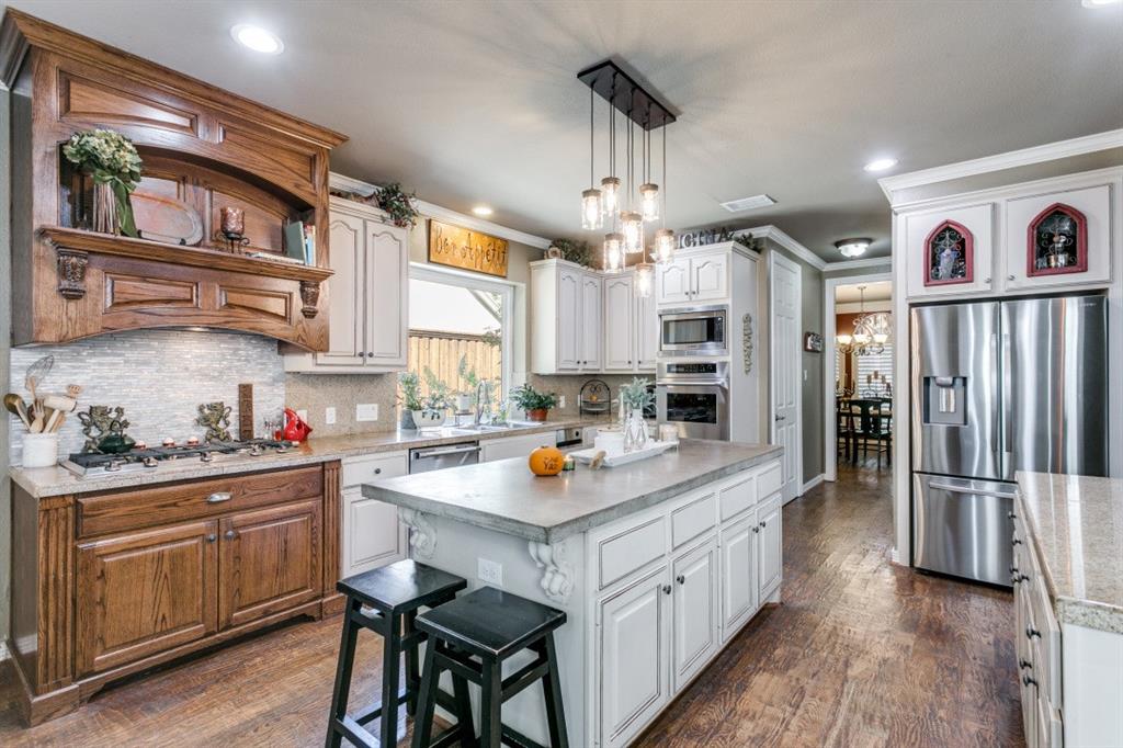 707 Bent Tree Court Coppell, TX 75019 - Photo 6 of 39 a kitchen with stainless steel appliances granite countertop a refrigerator a sink dishwasher a stove and white cabinets with wooden floor
