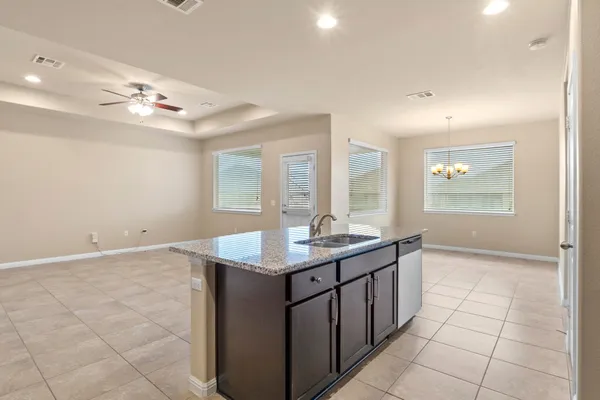 a kitchen with stainless steel appliances granite countertop a sink stove microwave and refrigerator