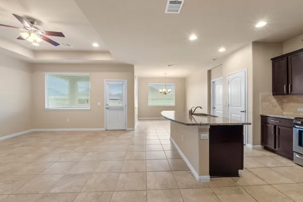 a large kitchen with stainless steel appliances kitchen island granite countertop a refrigerator a sink a dining table and chairs