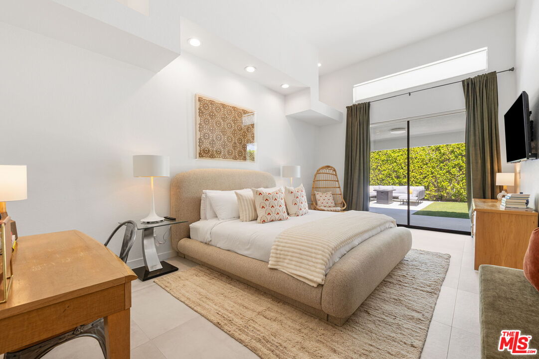 1414 Sagebrush Road Palm Springs, CA 92264 - Photo 28 of 48 a bedroom with a large bed and a flat tv screen on dresser