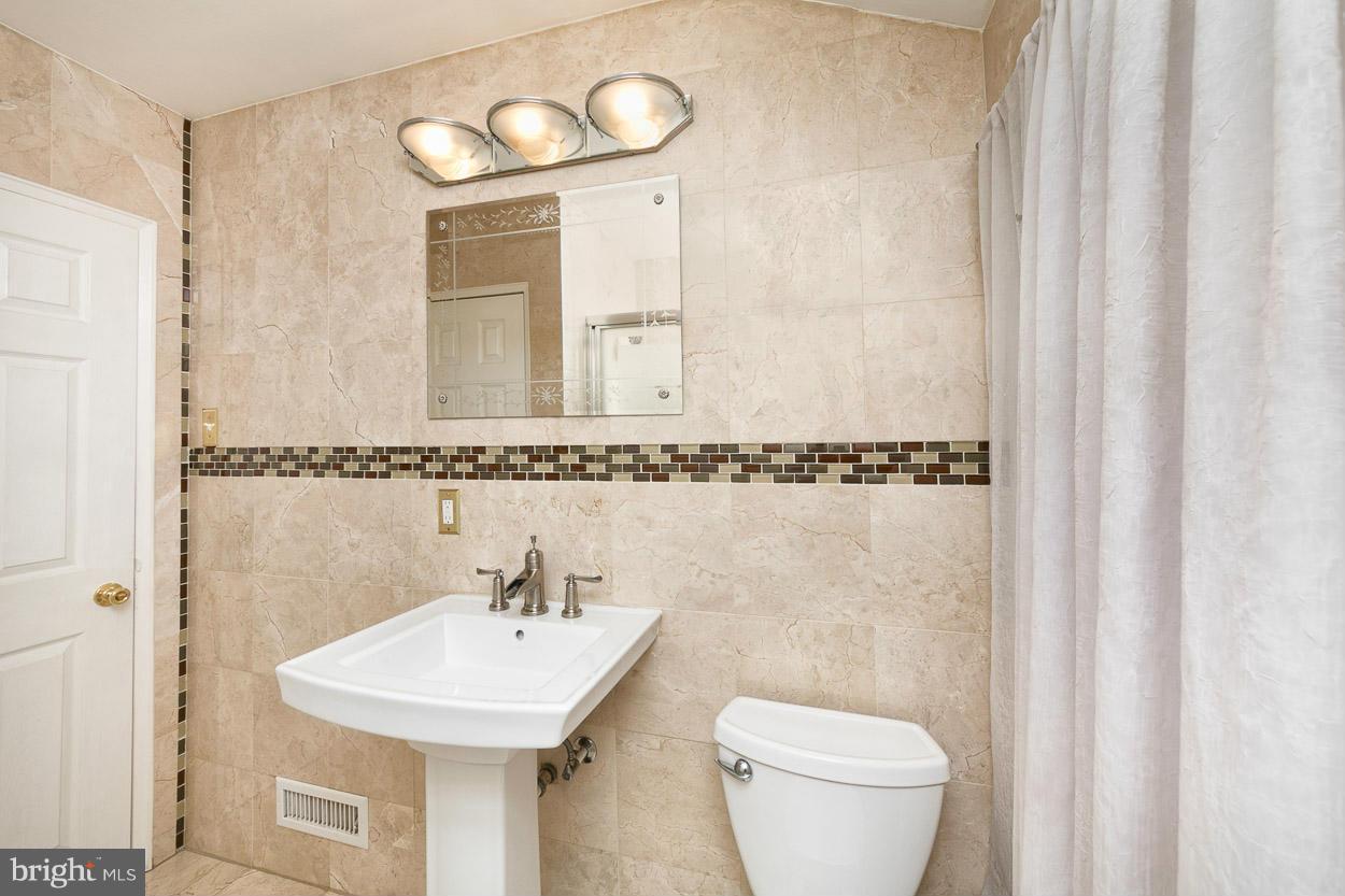 573 Brisbane Road Baltimore, MD 21229 - Photo 21 of 30 a bathroom with a toilet a sink and mirror