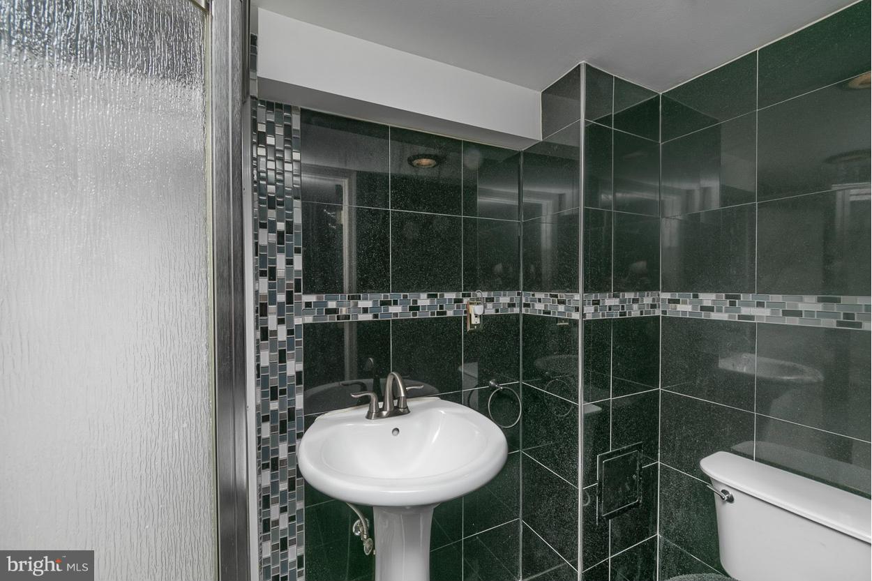 573 Brisbane Road Baltimore, MD 21229 - Photo 28 of 30 a bathroom with a sink toilet and a mirror