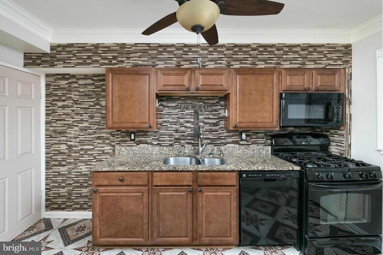 573 Brisbane Road Baltimore, MD 21229 - Photo 6 of 30 a kitchen with stainless steel appliances granite countertop a stove and a sink