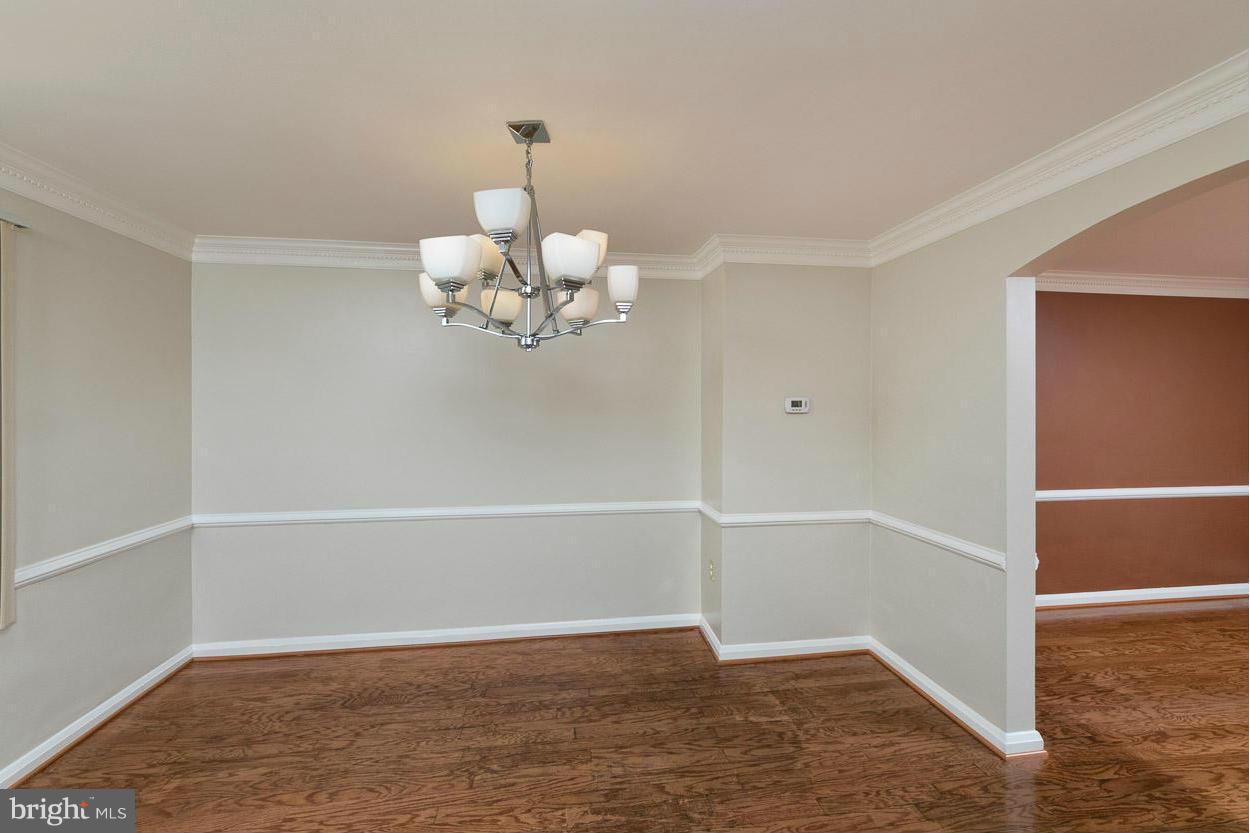 573 Brisbane Road Baltimore, MD 21229 - Photo 7 of 30 an empty room with wooden floor and chandelier