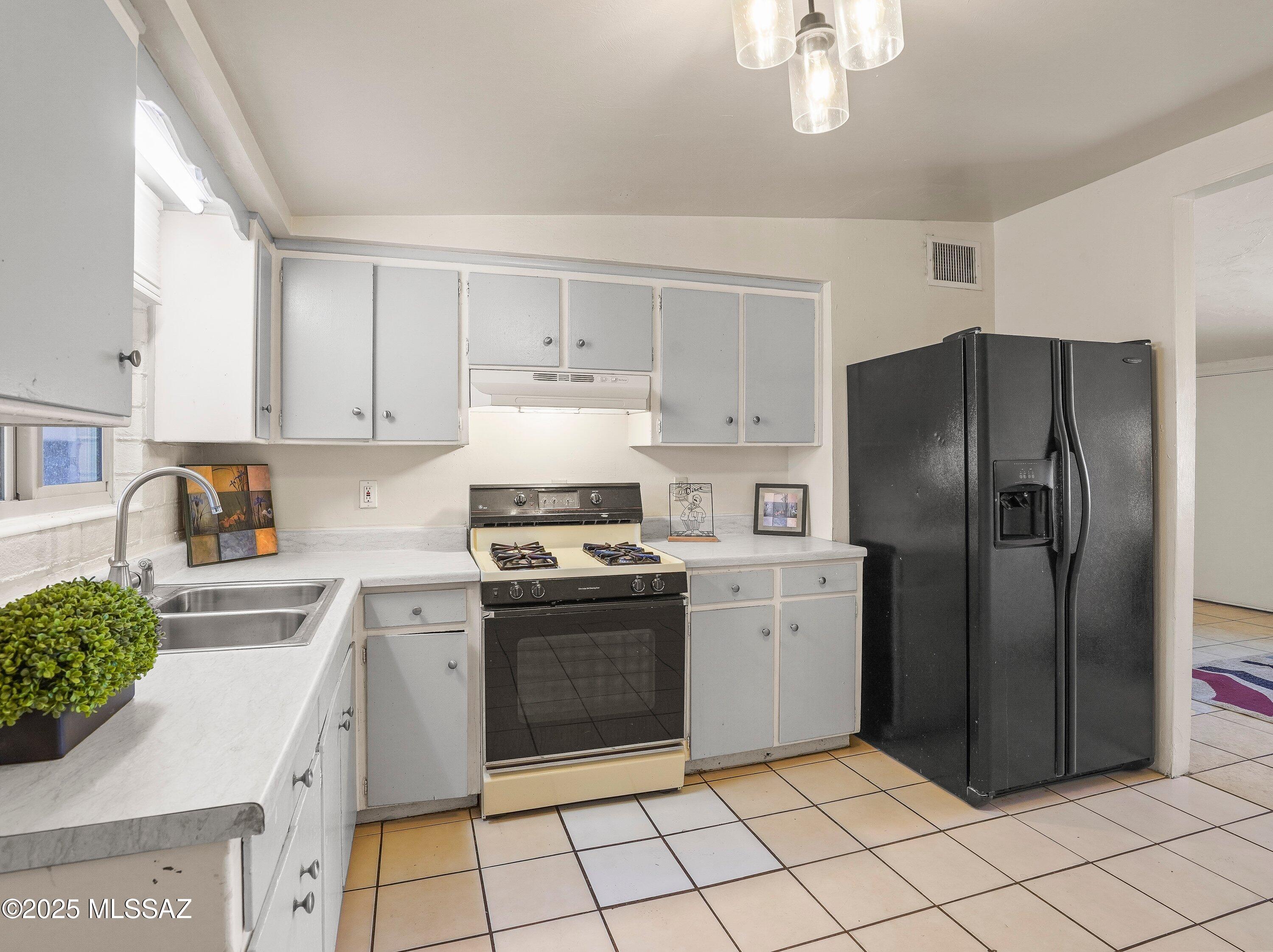 2001 South 3rd Avenue Tucson, AZ 85713 - Photo 10 of 42 a kitchen with stainless steel appliances granite countertop a refrigerator sink and stove