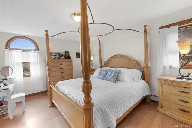 a bedroom with a bed and a mirror on the dresser