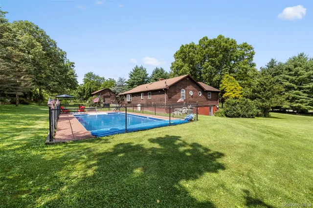 a view of a swimming pool with a bench and trees around