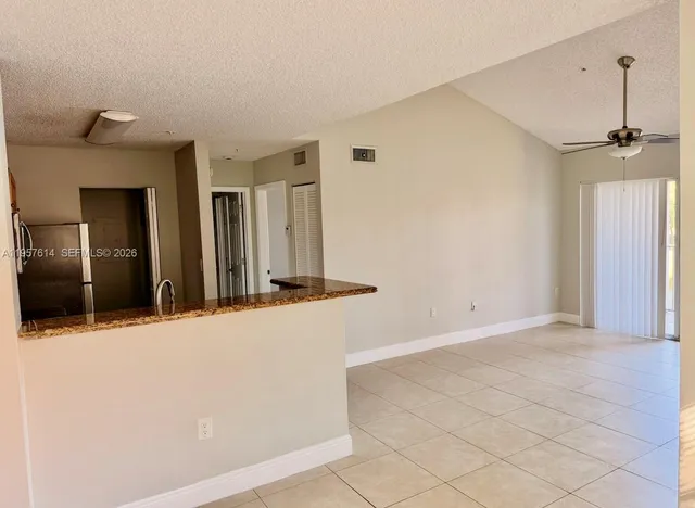 a kitchen with a refrigerator sink and cabinets