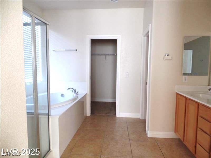118 Castle Course Avenue Las Vegas, NV 89148 - Photo 15 of 56 Full bathroom featuring vanity, a stall shower, light tile patterned floors, a garden tub, and a walk in closet