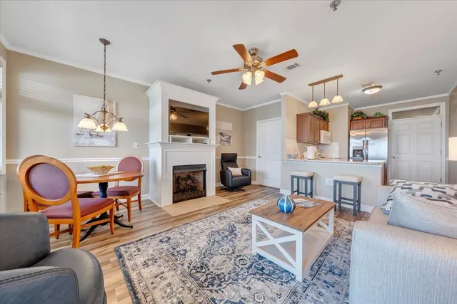 a dining room with wooden floor a chandelier a wooden table and chairs