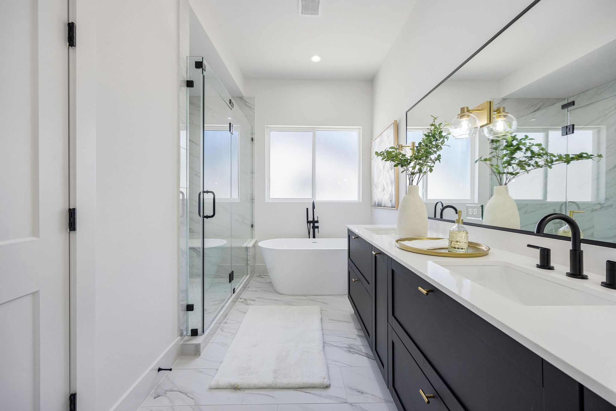 303 Marcella Street, Unit O Houston, TX 77091 - Photo 4 of 26 Luxurious primary bath featuring elegant marble finishes, a spacious glass-enclosed shower, a freestanding luxurious tub, and a double vanity with ample storage.