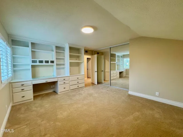 an empty room with cabinet and mirrors