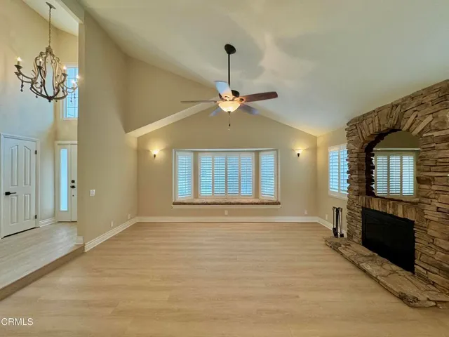 a view of an empty room with a fireplace and a window