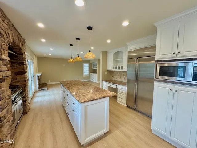 a kitchen with stainless steel appliances granite countertop a sink a stove and a refrigerator