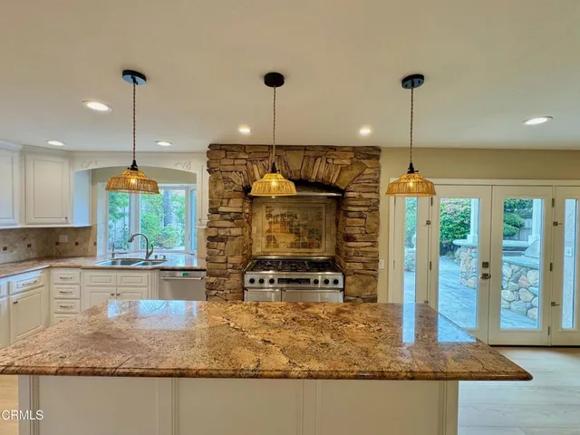 a kitchen with kitchen island a counter top space appliances and cabinets