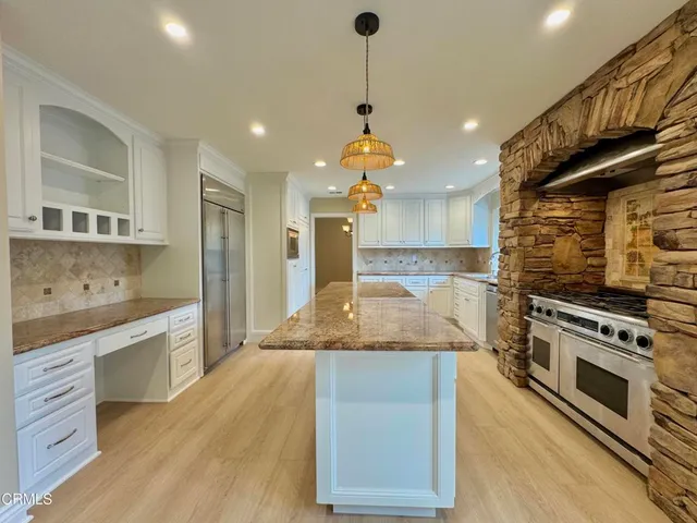 a large kitchen with granite countertop a stove and a sink