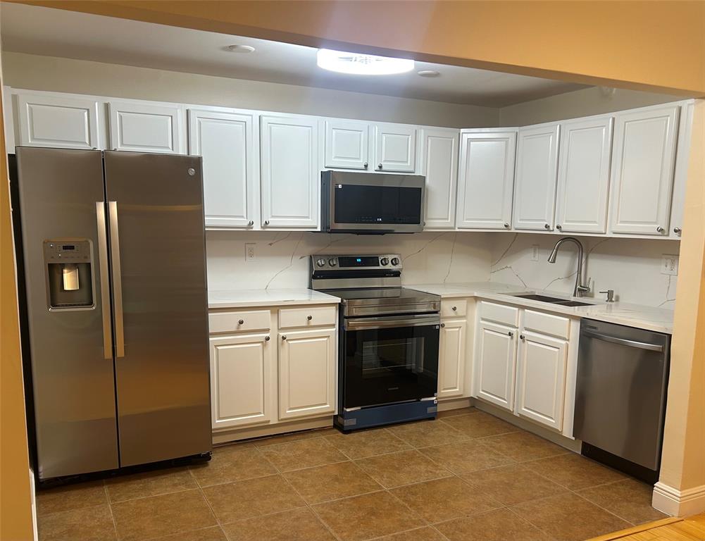 4116 Northwest 88th Avenue, Unit 202 Coral Springs, FL 33065 - Photo 1 of 16 a kitchen with stainless steel appliances granite countertop a refrigerator stove a sink and dishwasher with wooden cabinet