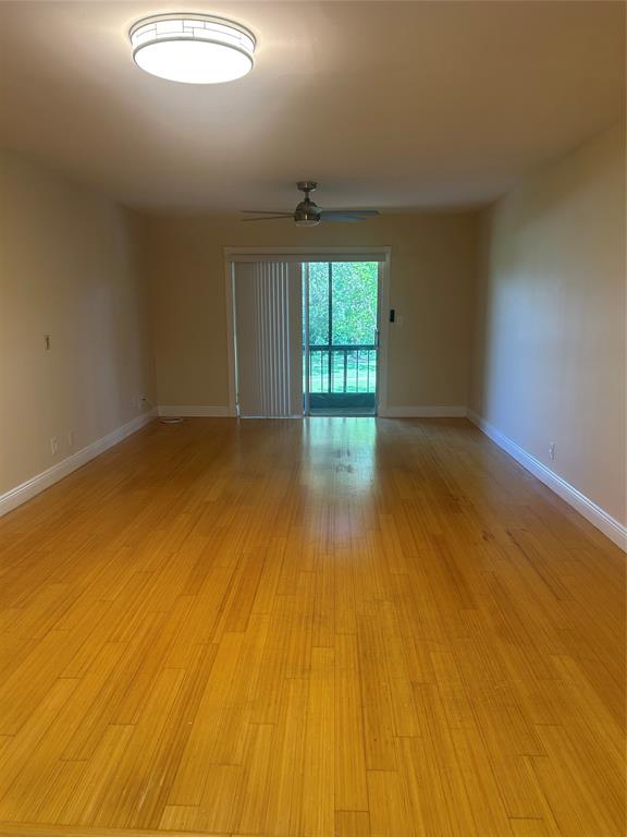 4116 Northwest 88th Avenue, Unit 202 Coral Springs, FL 33065 - Photo 6 of 16 an empty room with wooden floor and windows