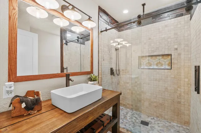 a bathroom with a sink mirror and a shower
