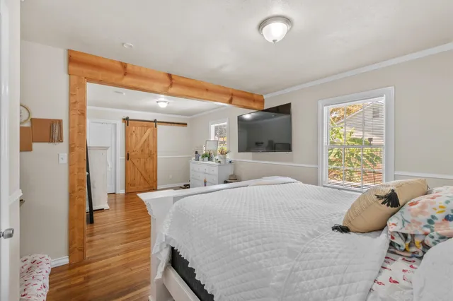 a bedroom with a bed and wooden floor