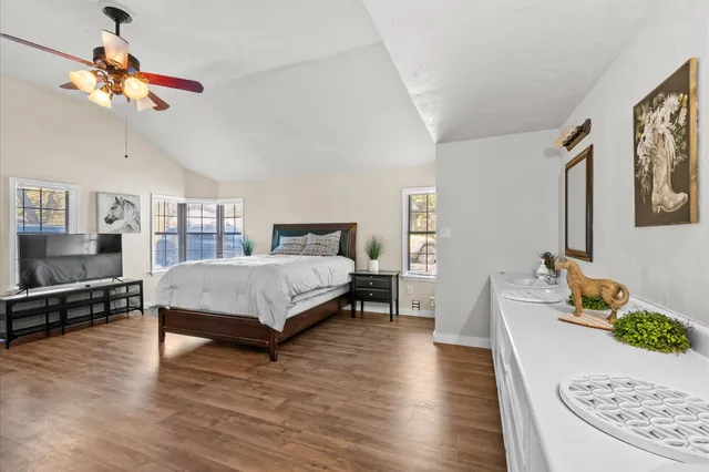 a bedroom with a bed chandelier and a window