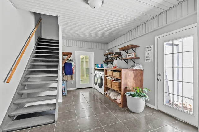 a view of a hallway with front door and wooden floor