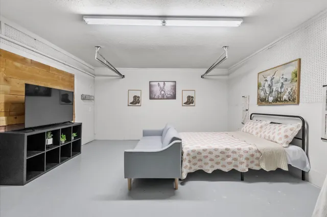 a bedroom with a bed and a flat screen tv