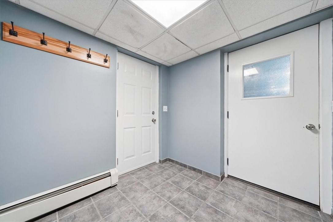 214 Anan Wade Road Glocester, RI 02857 - Photo 30 of 50 Convenient ground-level mudroom entrance from the driveway with durable tile flooring and direct access to both the finished lower level and garage.