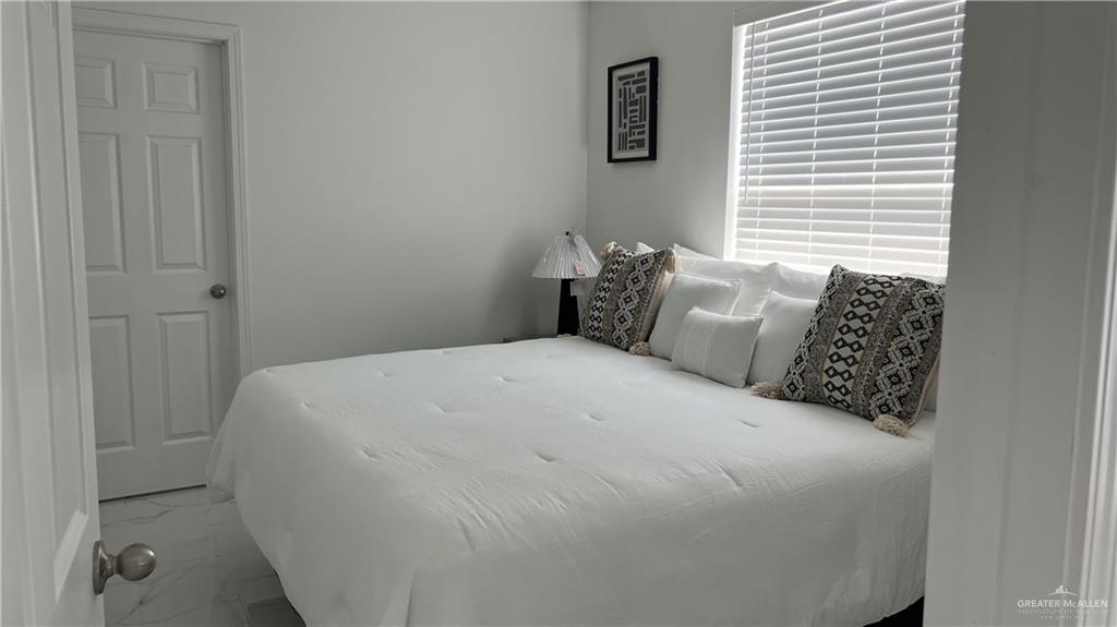 318 Sun Dial Circle Port Isabel, TX 78578 - Photo 11 of 19 a large bed sitting in a bedroom next to a window