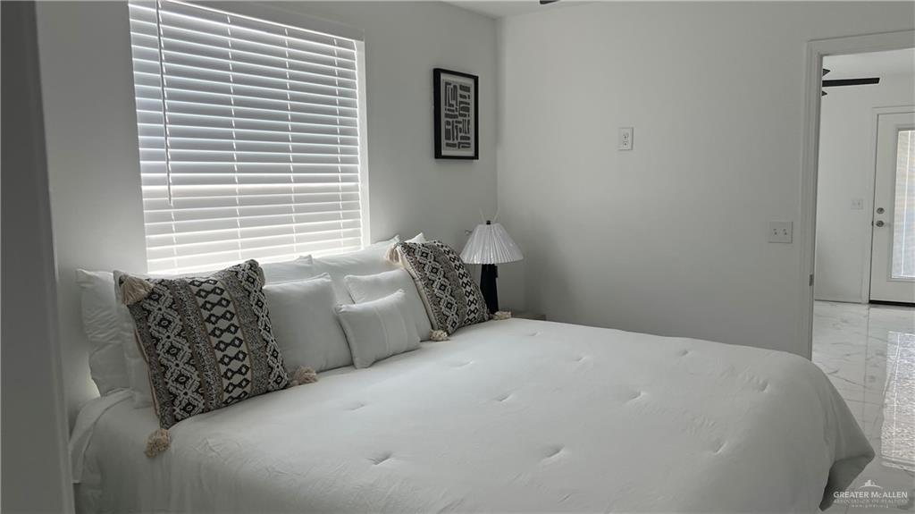 318 Sun Dial Circle Port Isabel, TX 78578 - Photo 12 of 19 a large bed sitting in a bedroom next to a window and lamp
