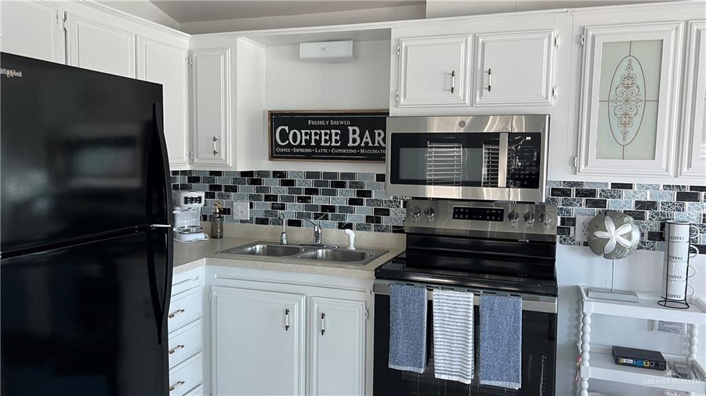 318 Sun Dial Circle Port Isabel, TX 78578 - Photo 6 of 19 a kitchen with a refrigerator and a stove