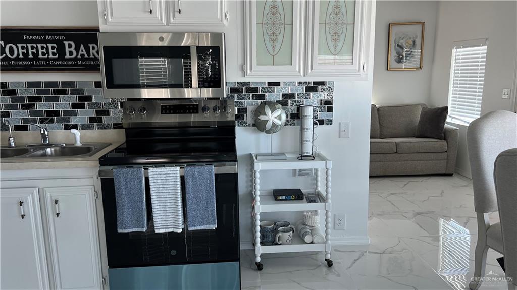 318 Sun Dial Circle Port Isabel, TX 78578 - Photo 7 of 19 a kitchen with stainless steel appliances a stove a sink and a microwave