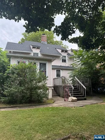 a view of a house with pool and a bench