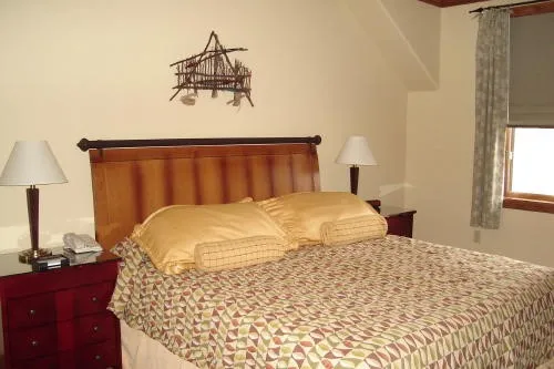 a bedroom with a bed and a lamp on dresser