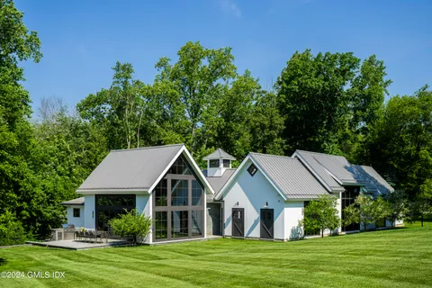 a aerial view of a house with a big yard potted plants and large tree