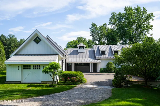 a front view of a house with a yard and potted plants