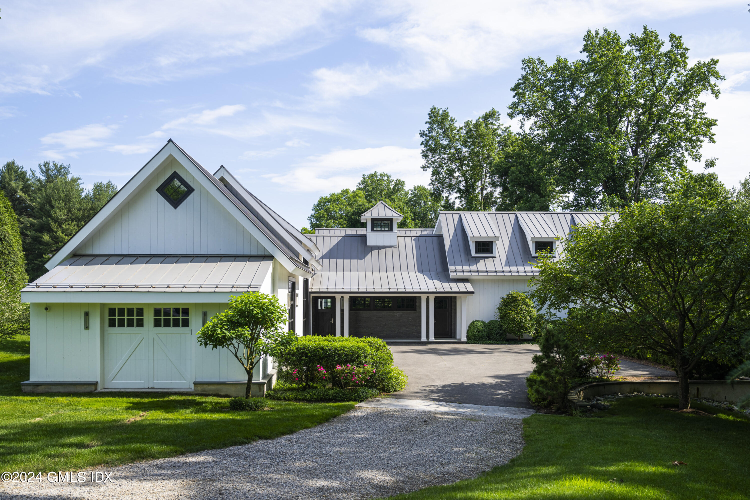 865 Hollow Tree Ridge Road Darien, CT 06820 - Photo 23 of 37 a front view of a house with a yard and potted plants