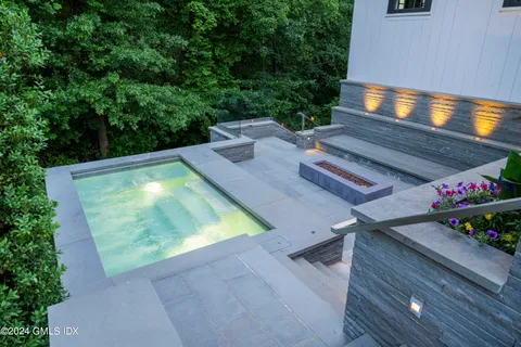 a view of a backyard with chairs and a potted plant