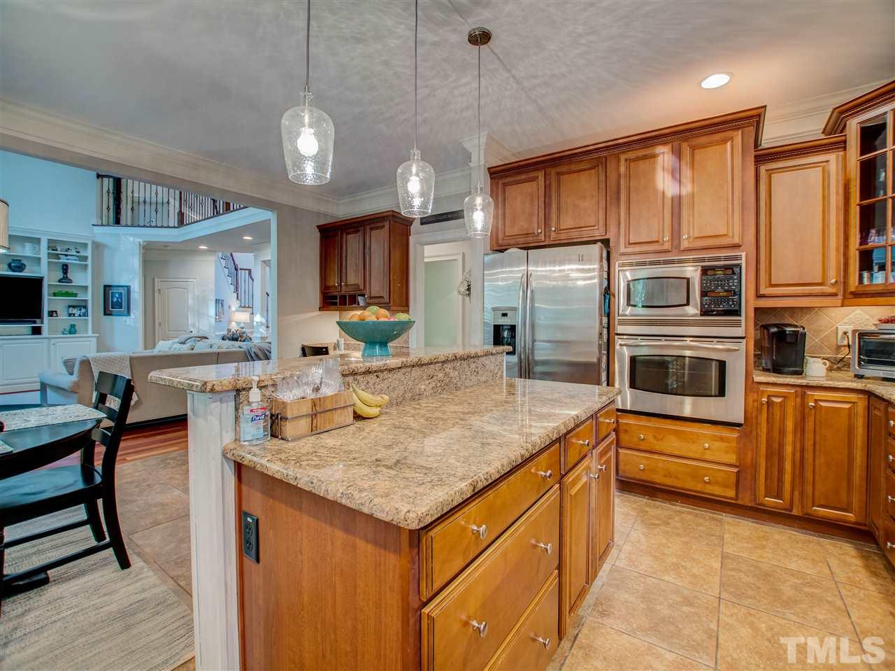 4307 Oakthorne Way Raleigh, NC 27613 - Photo 13 of 30 a kitchen with stainless steel appliances granite countertop a stove top oven a sink dishwasher a dining table and chairs with wooden floor