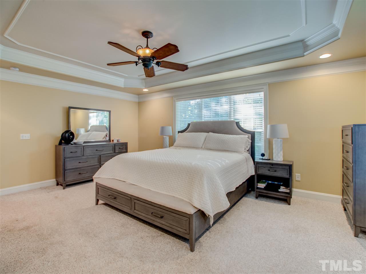 4307 Oakthorne Way Raleigh, NC 27613 - Photo 17 of 30 a spacious bedroom with a bed and a chandelier