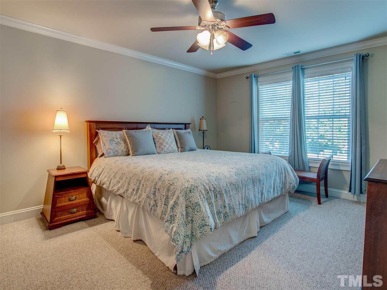 4307 Oakthorne Way Raleigh, NC 27613 - Photo 22 of 30 a spacious bedroom with a bed and a chandelier